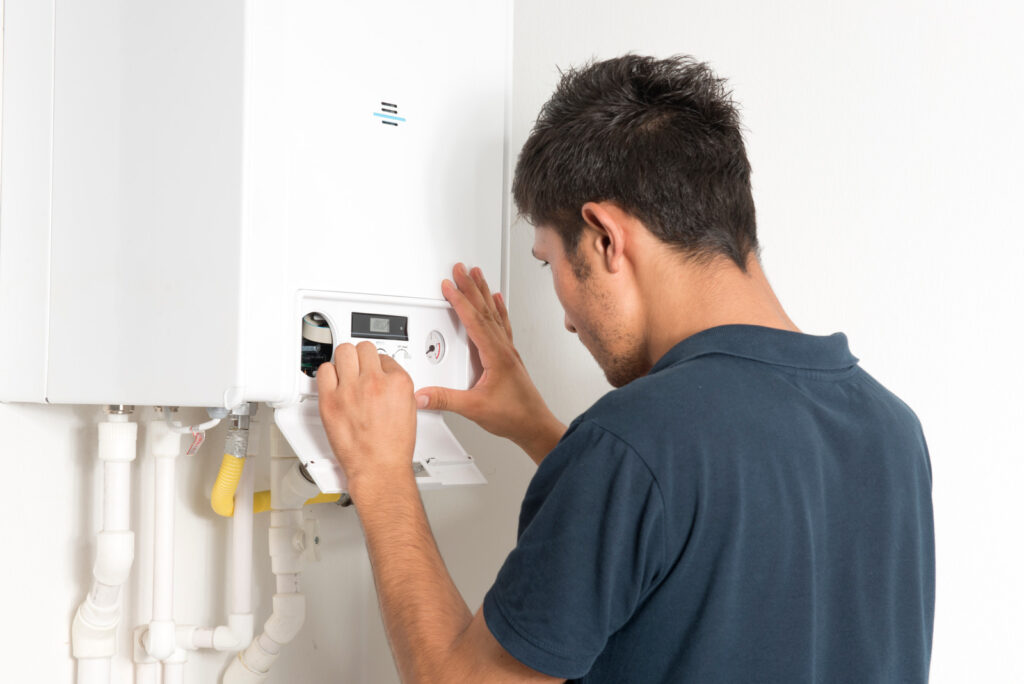 A2B Plumbing technician in Burnaby, BC, inspecting a residential boiler heating system.
