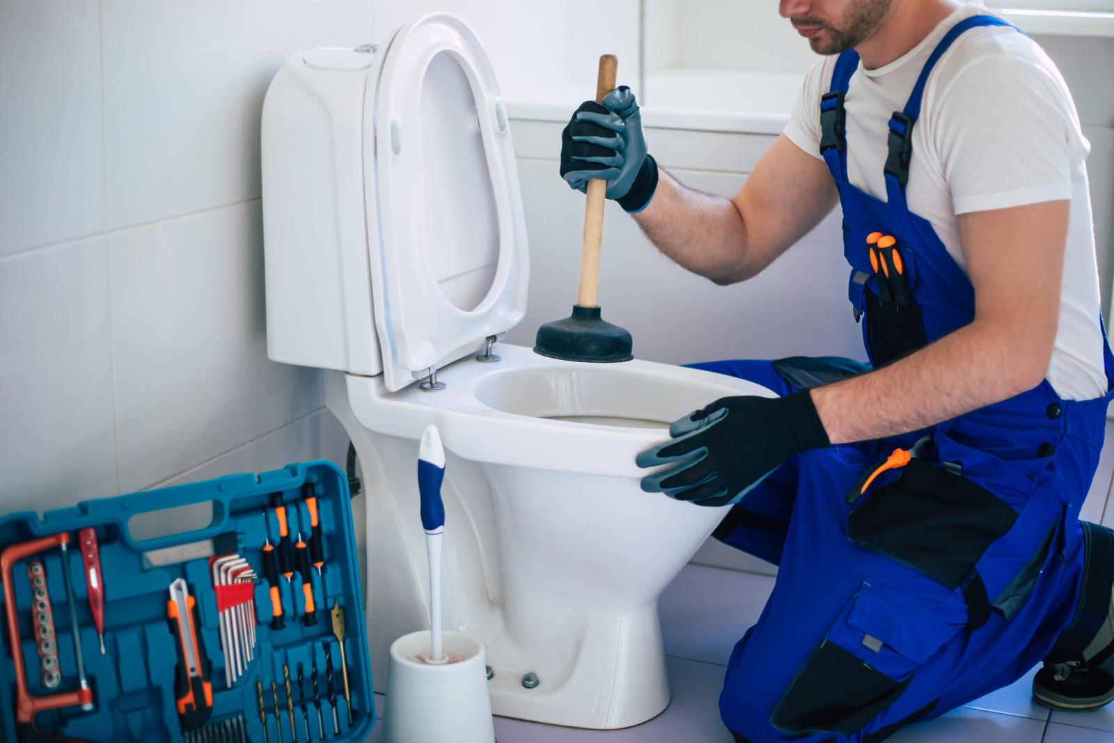 A2B Plumbing technician in Burnaby, BC, repairing a malfunctioning toilet in a residential bathroom